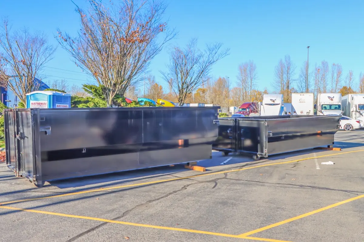 Professional dumpster rental service with roll-off container on residential driveway in North Hills